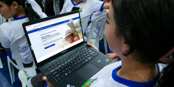 Joven usando laptop con web de Carpeta Ciudadana Digital