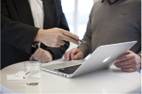 Dos hombres colaborando frente a una laptop realizando una Consultoría en la Política de Gobierno Digital