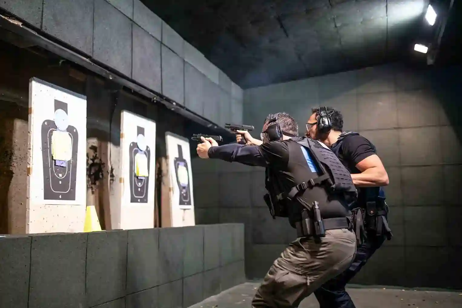 Instructores en un simulador de tiro practicando con armas de fuego